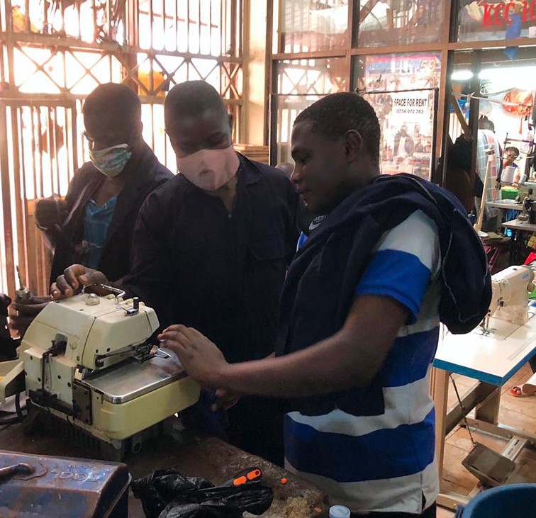 John Kigozi with one of his employees in the shop